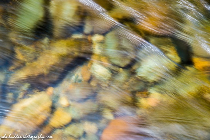 Flowing water blurs river bottom stones in the Huntington River