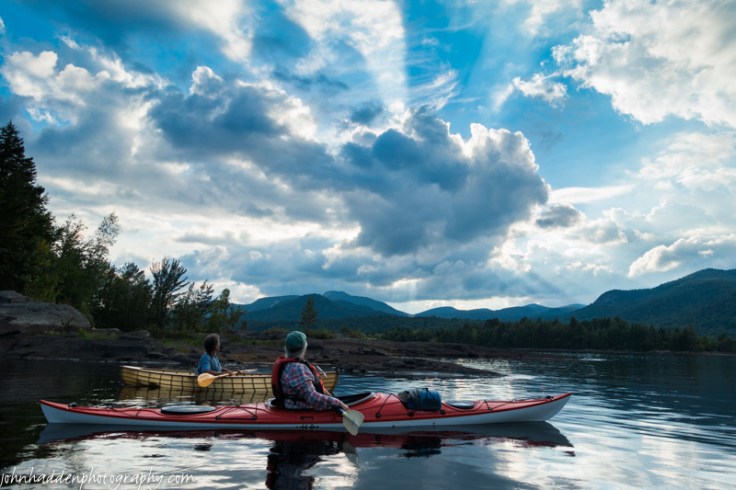 Crepuscular rays burst from behind the clouds above Indian Lake